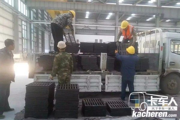 工人往東風輕卡上裝載貨物